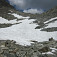 Snehové pole pod sedlom, v skalách naľavo začína ferrata